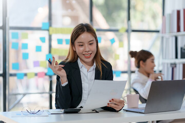 Young Asian businesswoman working document and project in modern office. Financier working with documents at workplace.