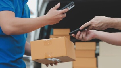 Fast and reliable service. Cheerful young delivery man giving a cardboard box to young woman while standing at the entrance of her apartment