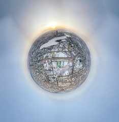Aerial winter city view with crossroads and roads, houses, buildings, parks and bridges. Copter shot. Little planet sphere mode.