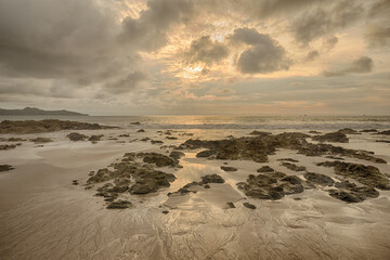 Cloudy landscape of an ocean rocky beach.