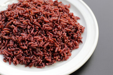 Cooked black rice on dark background.