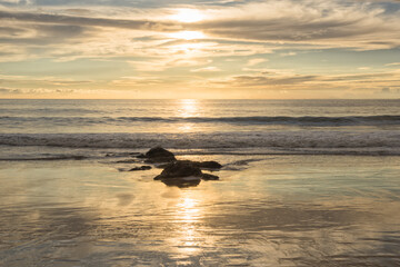 Golden Sunset on the Ocean with Rocks in the Foreground