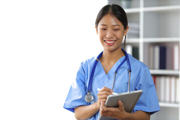 Portrait smiling Asian female medical student and holding tablet. Doctor's assistant in a clinic office at a hospital.