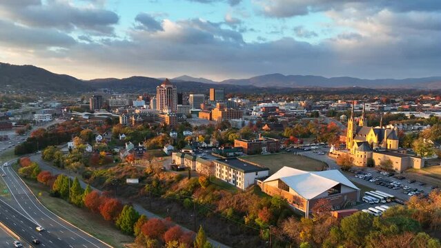 Roanoke, Virginia during golden hour sunrise. Aerial shot of Catholic cathedral and panning towards downtown skyline during autumn.