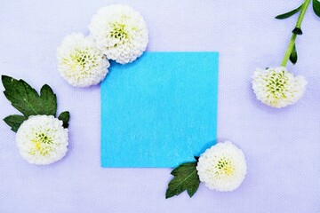 薄い紫背景に白のピンポンマムと緑の葉を飾った青くオシャレなタイトルスペースのモックアップ