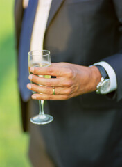 Verre de champagne dans la main d'un homme marié lors d'un cocktail