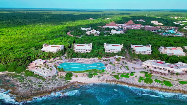 Tulum Mexico TRS Yucatan Resort drone view of the Caribbean Sea with large waves crashing on the beach with a view of the infinity and salt water pools.
