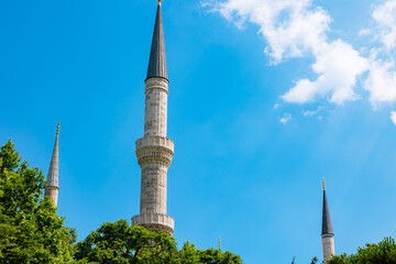Fototapeta na wymiar Islamic background photo. Minarets of a mosque isolated on blue sky background