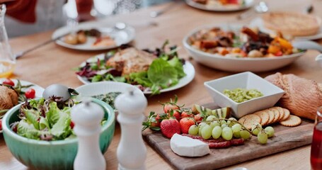 Table, food and hand of man at a family lunch, reunion or social gathering. Health, nutrition and closeup of people eating at a buffet for Christmas, party or brunch, event and celebration outdoor