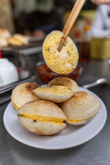 Vietnamese Street Food in Da Lat city, Vietnam - Banh can on the warm ember stove kitchen. Food and travel concept.
