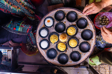 Vietnamese Street Food in Da Lat city, Vietnam - Banh can on the warm ember stove kitchen. Food and travel concept.