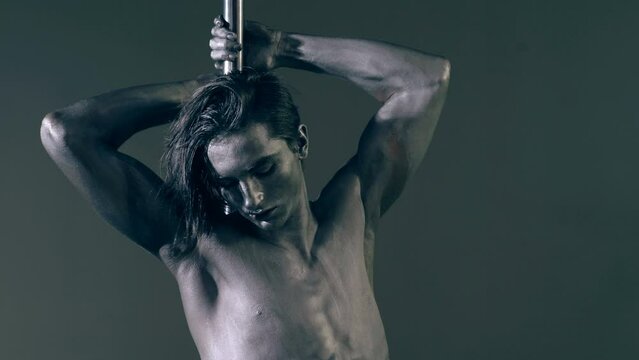 Pole dance. Sexy man dancing on pylon. Sexy slim and muscular male body. Flexible man gymnastic dancer man performing. Strong guy on pole dance. Shirtless gymnast exercising on pylon. Bare male torso.
