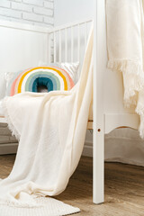 Kid's room interior with comfortable bed and rainbow pillow