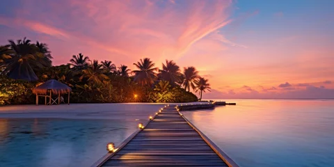 Foto op Aluminium Sunset on Maldives island, luxury water villas resort and wooden pier. Beautiful sky and clouds and beach background for summer vacation holiday and travel concept © Rozeena