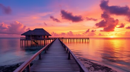 Fototapeta na wymiar Sunset on Maldives island, luxury water villas resort and wooden pier. Beautiful sky and clouds and beach background for summer vacation holiday and travel concept