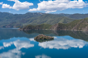 The reflection of blue sky and white clouds on the water surface of Lugu Lake in China