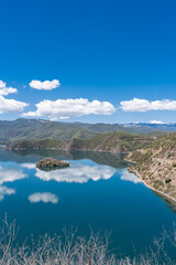 The reflection of blue sky and white clouds on the water surface of Lugu Lake in China