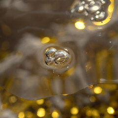 Cosmetic product with air bubbles and glitter on festive glitter background