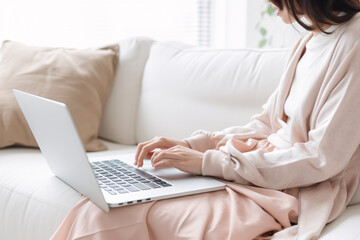 Naklejka premium ソファーでノートパソコンを使っている女性の手のクローズアップ