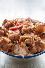 angle view bowl of rice with pork ribs and slices of Chinese style sausage at vertical composition