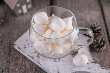 Small meringues in a transparent mug on a winter background