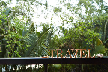 'TRAVEL' wooden alphabet word on garden railing