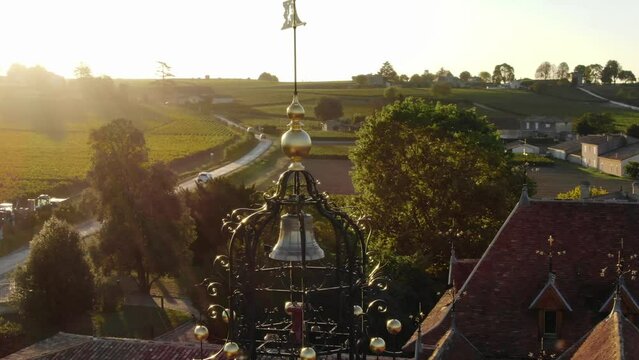 Drone flying around bell tower of Chateau Angelus winery, Saint Emilion in France. Aerial orbiting