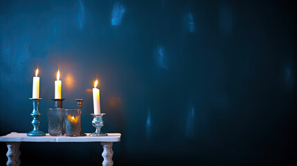 candlesticks with burning candles on dark blue background 