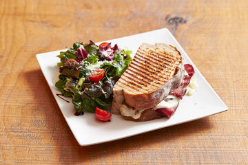 salami sandwich and salad on plate