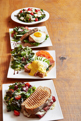 Various brunch food and salads on wooden table