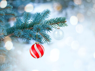 Fototapeta na wymiar Christmas tree branch with red Christmas ornaments on bokeh background