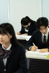 教室で勉強している制服の高校生