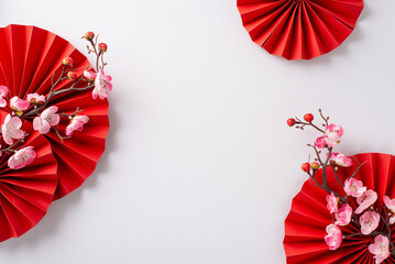 Festive arrangement for Lunar New Year, featuring red fans, and pink sakura flowers. Top view on a...
