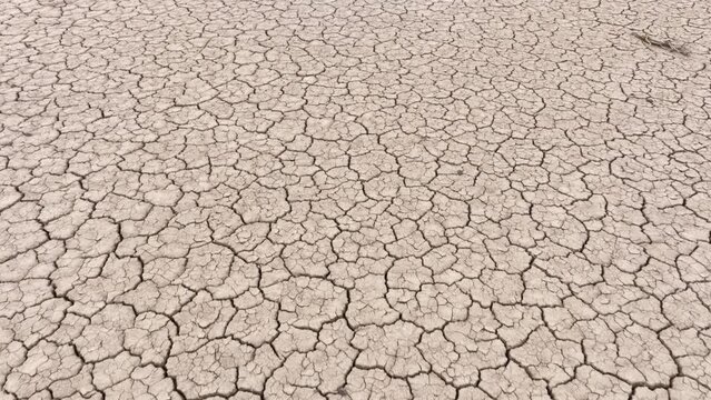 Aerial shot looking down at the cracked surface of a dry lake in Navada