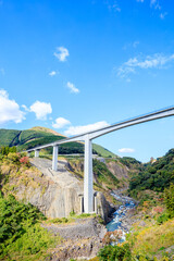 Fototapeta na wymiar 初秋の新阿蘇大橋　熊本県阿蘇郡　Shin-Aso Ohashi Bridge in early autumn. Kumamoto Pref, Aso-gun.