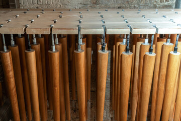 Collection of new wooden furniture legs drying after applying varnish hanging in wood workshop...