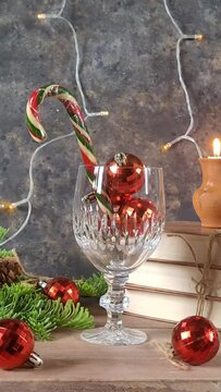 Rustic Christmas greeting Card with Christmas ball and candy cane in wine glass. Creative Vertical video with XMAS decoration in rerto style. XMAS mood. 