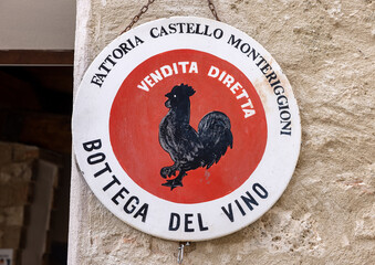 Naklejka premium Black rooster symbol of good wine in Tuscany hanging on the wall of a house in Monteriggioni medieval walled town near Siena. Italy
