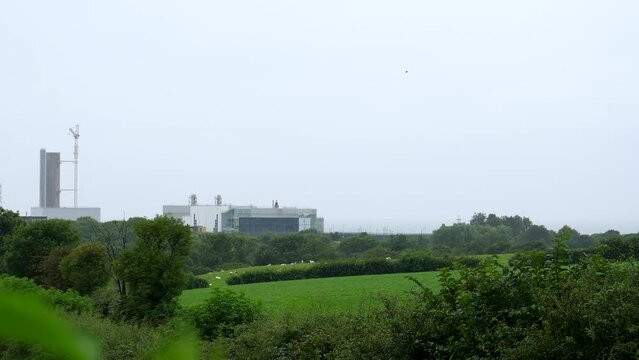 Closed Sellafield nuclear power station panning shot in summer rain.