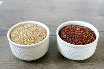 Red and white quinoa on the two white plates on the wooden background. Healthy food and nutrition concept. Safe, ecological, and healthy products