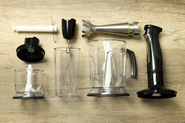 Black blender with attachments on wooden background, top view