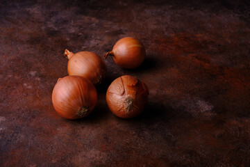 Obraz premium Unpeeled onions on a textured old table. Organic vegetables from the farmers market. Selective focus