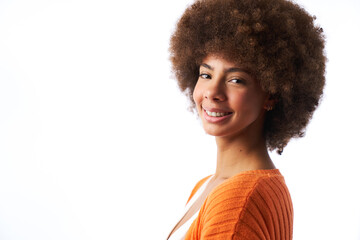 portrait of smiling latina woman with afro hair looking into camera on white background