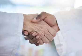 Fotobehang Science, shaking hands and agreement in laboratory for onboarding, deal or gratitude. Welcome, medical research and scientist in handshake for partnership, collaboration or introduction for doctors. © Siphosethu/peopleimages.com