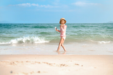 Fototapeta na wymiar A child girl 6 years old plays on the beach with waves. One preschool-age girl on the seashore