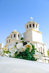 Obraz premium A rose-decorated wedding car against the backdrop of a church's glittering gilded domes. Vertical orientation. Selective focus.