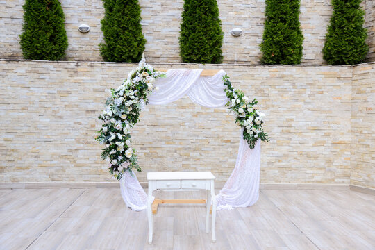 Wedding arch with decoration of roses in white and green. Vintage style. Selective focus.