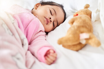 Baby, girl and sleeping in bed with teddy bear, animal and peace in home with blanket and comfort. Child, rest and sleep in morning, nap and routine for health, wellness and calm face of infant
