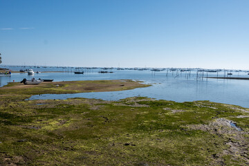 View on Arcachon Bay at low tide with many fisherman's boats and oysters farms, Cap Ferret peninsula, France, southwest of Bordeaux along France's Atlantic coastline