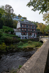 Fototapeta na wymiar View of houses and streets of old colourful German town Monschau in bend of the river and hidden between the hills, Eifel national park, Germany